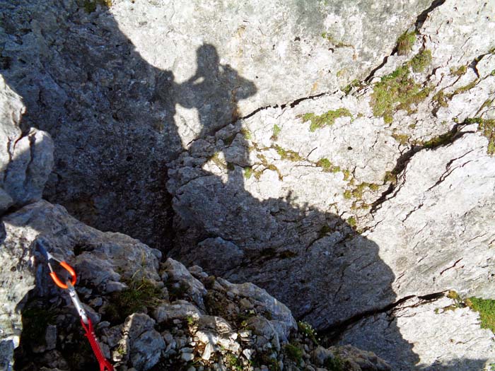 in eine breite Kluft quer durch die Gratschneide klettert man einige Meter leicht überhängend ab und spreizt mit einer Linksdrehung über den ausgesetzten Schlund; jenseits die steile Wand empor, 2 Sanduhren