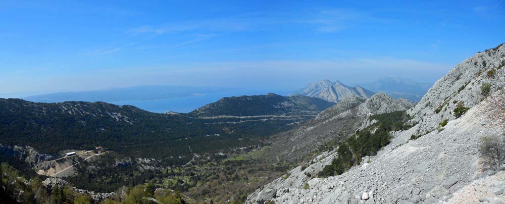 der breite Talgrund vom Eingang ins Hochtal; links draußen die Insel Brač, rechts an der Kante des grünen Bandes Sveti Nikola, die breite Schneise in Bildmitte führt zum Sattel oberhalb von Brela 