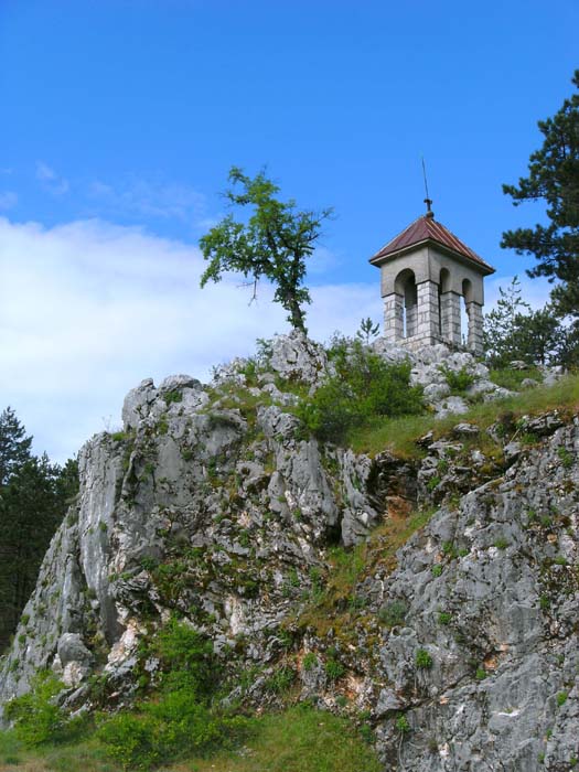 am Fuß des Felsens liegt der Eingang zu einer Tropfsteinhöhle