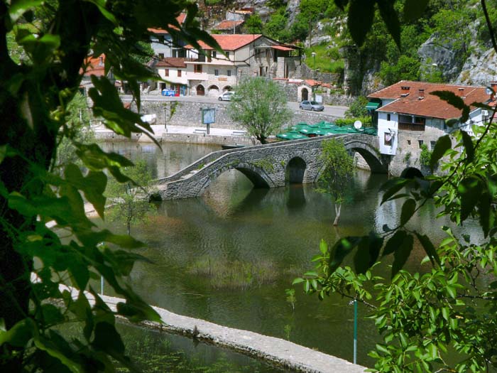 ein geschwungener Damm verlängert die Brücke ans andere Ufer