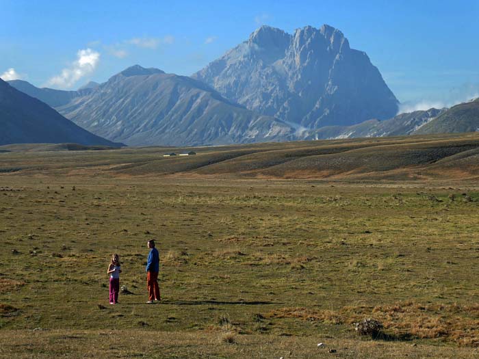 Ulli und Ronja auf dem Campo Imperatore, der nach dem Stauferkaiser Friedrich II. benannten 80 km² großen Hochebene südlich des Gran Sasso; von Frühling bis Herbst werden hier ungepfercht Schafe, Kühe und Pferde aus den umliegenden Dörfern gehalten, die Landschaft diente schon als Schauplatz für ca. 20 Kinofilme. Im Hintergrund Monte Aquila (links) und Corno Grande, wir erklimmen die Berge von links