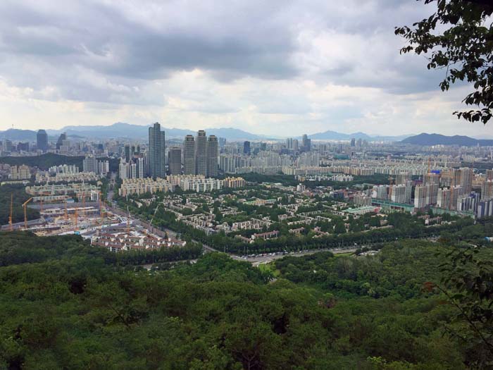 die 30-Millionen-Stadt Seoul ist durchsetzt von großen Grüngebieten. Blick aus der Nordflanke des Guryonsan übers Stadtzentrum auf den Bukhansan-Nationalpark: Der Baekundae verbirgt sich hinterm höchsten Turm, die Dobongsangruppe steht rechts hinter den Drillingen