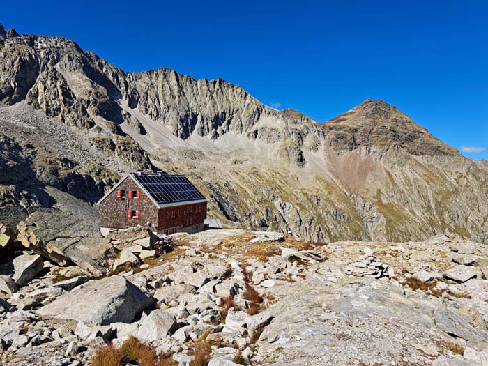 sie ist längst nicht so überlaufen wie viele andere Schutzhäuser der Ostalpen; die dreigipfelige Patscher Schneid überm Hüttendach war einmal eine begehrte Klettertour, wird heute aber eher gemieden; rechts das Rosshorn sie ist längst nicht so überlaufen wie viele andere Schutzhäuser der Ostalpen; die dreigipfelige Patscher Schneid überm Hüttendach war einmal eine begehrte Klettertour, wird heute aber eher gemieden; rechts das Rosshorn
