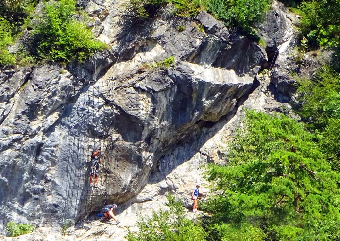 unten vom Ort erkennt man über den Baumwipfeln den Ausstieg des eben begangenen „Burgforst“ und daneben das Kletternetz des schwierigeren „Draublick“, ...