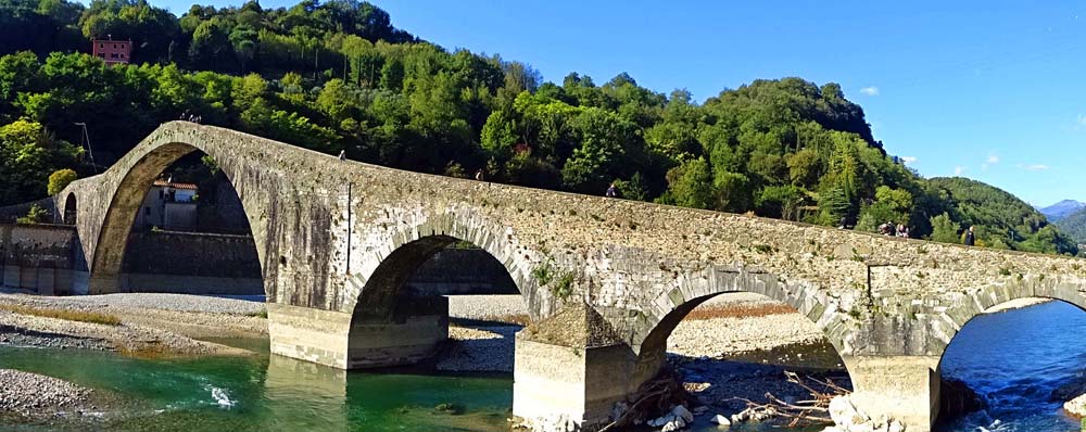 noch ein paar Eindrücke von unserer Weiterfahrt zum Tyrrhenischen Meer: Kurz hinter dem einstmals weltberühmten Kurort Bagni di Lucca treffen wir in Borgo a Mozzano auf die Ponte della Maddalena, auch Teufelsbrücke. Laut einer Sage wollte Il Diabolo eine Brücke über den Serchio bauen, wenn er dafür die Seele des ersten Passanten bekäme. Die Einheimischen schickten nach der Fertigstellung einen Hund hinüber