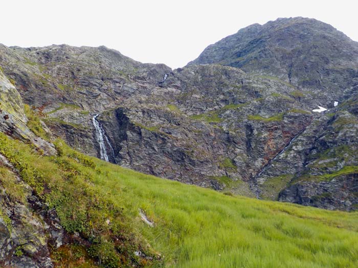 in der folgenden Steilstufe gabelt sich der Weg; der linke Wasserfall bildet den Abfluss des Geigensee; der rechte entwässert den Pumpersee, beim Schneefleck wechselt unser Steig zum rechten Bildrand hinüber