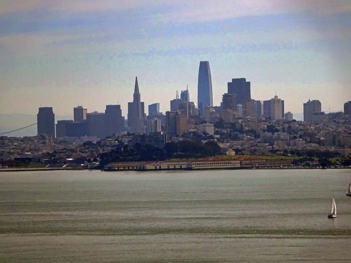 Blick von der Nordseite übers Goldene Tor auf Downtown San Francisco; links ist noch ein Stück der Oakland Bridge zu erkennen, über die alltäglich mehr als doppelt so viele Fahrzeuge unterwegs sind als auf der Golden Gate Bridge