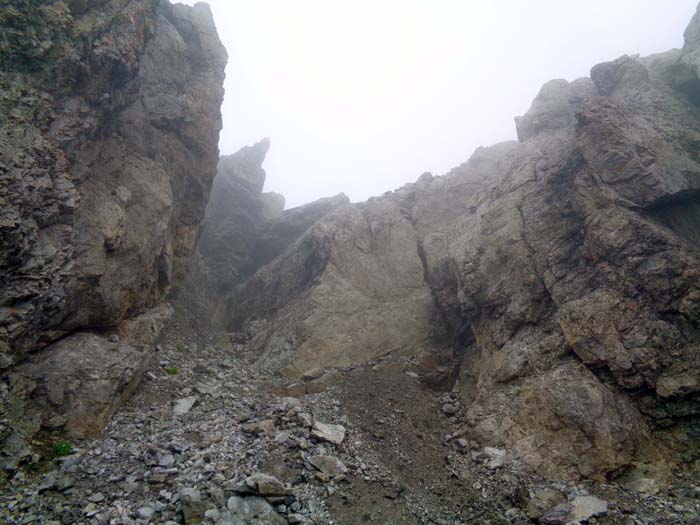vom Geröllspitz über die schmale, überdachte Rampe in kurzer Kletterei (II+) hinaus ...