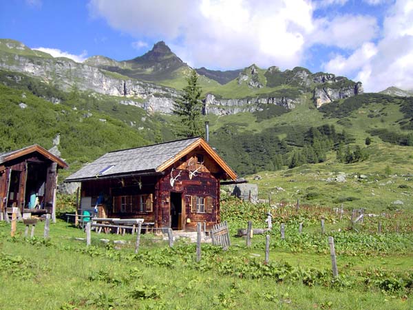 die teilweise bewirtschafteten Hütten am Beginn der weiten, überraschend flachen Hirzkaralm; genau über der Hütte der Mäuskarkopf, 2621 m