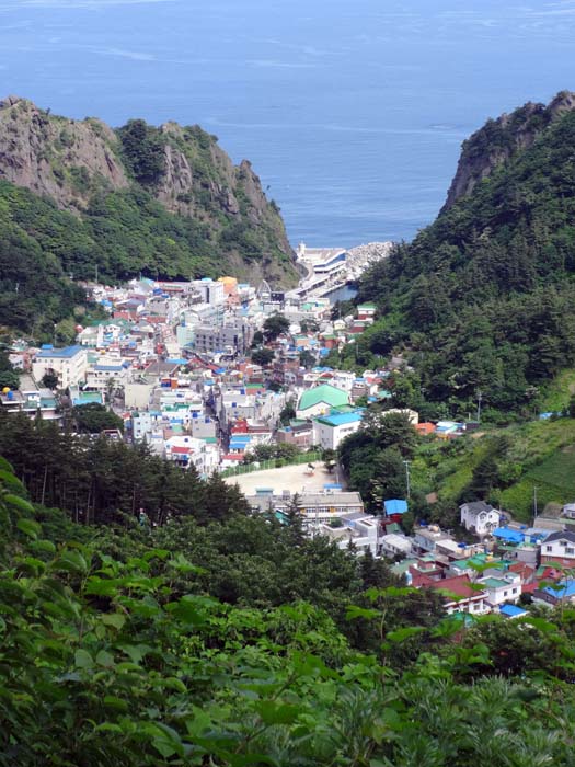 Tiefblick auf Dodong; die folgende Küstenwanderung beginnt am Felspfeiler links der Bildmitte