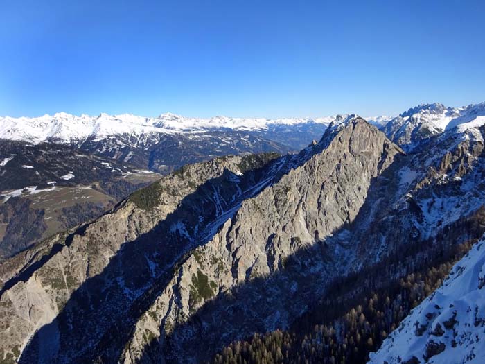 gleich links daneben zwischen den beiden Graten die „Schluck“, welche in schneereichen Wintern verführerisch auf die Pustertaler Höhenstraße hinüberblinzelt; über den linken Kamm verläuft der alte Marwiesensteig auf den Schluckenriegel (s. Archiv), die schwer zugängliche Schluck selbst verspricht ein heftiges Schitourenabenteuer und auch über den schneidigen Westgrat des Breitenstein (diagonal durch die Bildmitte) ist uns nichts bekannt