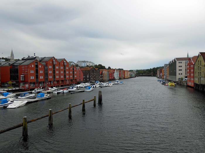 während die Vororte der norwegischen Küstenstädte oft an die amerikanische Provinz erinnern, können die alten Stadtkerne ganz reizvoll sein; hier die auf Pfählen im Wasser der Nidelva stehenden alten Speicherhäuser von Bryggene in Trondheim