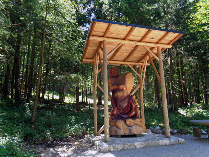 die Holzskulptur des Riesen Erla am Radmoos, der Senke zwischen Grünberg und Traunstein; der Riese spielt zusammen mit seiner Nixe Blondchen die tragische Hauptrolle in der Gründungssage von Schloss Orth im Traunsee