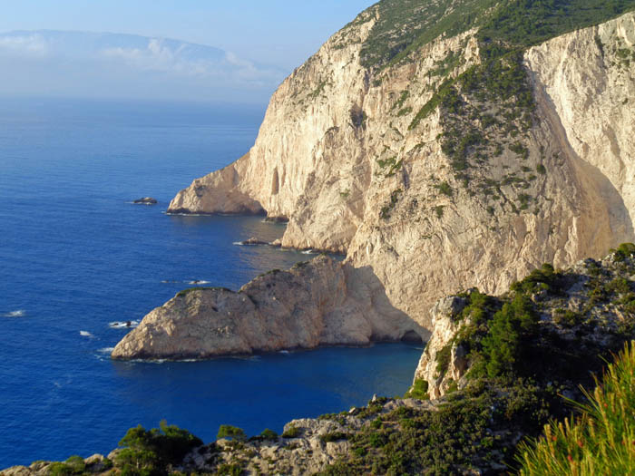 Abenteuerlustige können jenseits der Kuppe auf immer schlechter werdenden Ziegenpfaden dem bewachsenen Felsgrat hinunter zum Meer folgen; Blick gegen Norden auf Kefaloniá, die größere Nachbarinsel