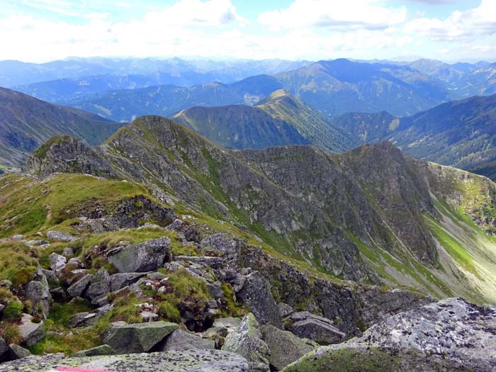 im Westen Hochleitenspitze und Wölzer Tauern; wir steigen auf schottrigem Pfad ins Kar nach rechts ab