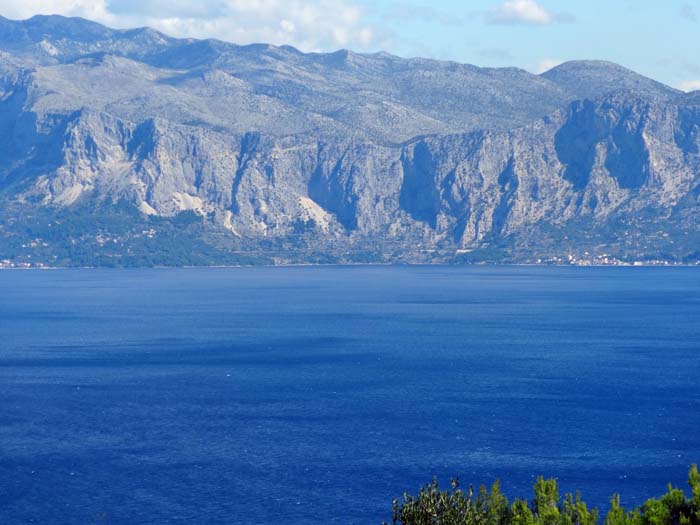 Blick aus der Brestova-Bucht auf der Insel Hvar zum Festland aufs neue Klettergebiet zwischen Podgora und Drašnice; die ersten Routen warten schon - in der halb abgeschatteten Wandbucht rechts der Bildmitte