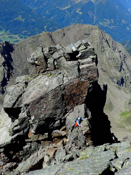 Ulli ist mittels einer Hangelleiste aus der schmalen Schattenwand (rechts) in die Scharte gelangt und überklettert soeben das zweite Schartentürmchen; weiter unten haben wir in einer horizontalen Kluft die gesamte Basis des massigen Turmes „durchquert“ und sind in die erwähnte Schattenwand ausgestiegen