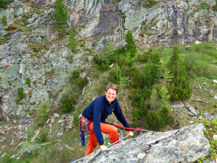 ... sowie ein kurzer Übungsklettersteig (C, 30 m), der den Turmgipfel umrundet; auf der gegenüber liegenden Hauptwand kann man schon die Seile der kreuz und quer verlaufenden Klettersteigvarianten erkennen