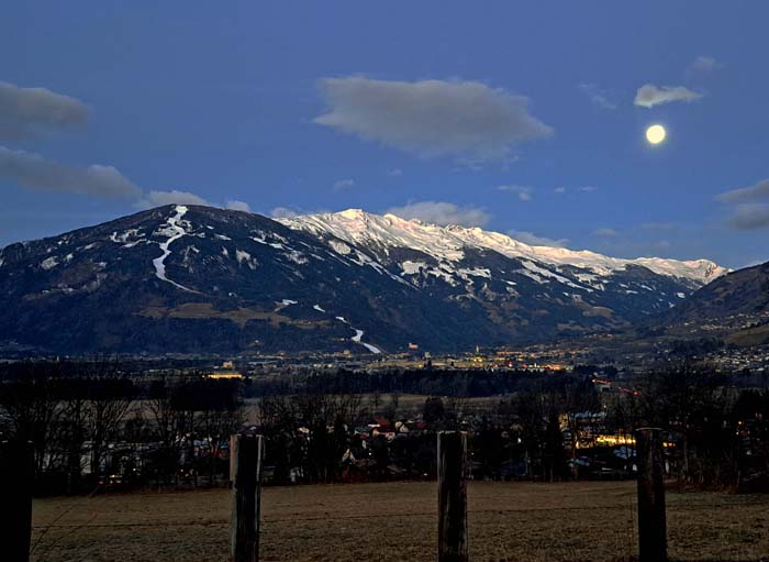 Blick frühmorgens von unserer Haustür auf Lienz mit dem grünen Hochstein und dem Bösen Weibele in Bildmitte; der Russenweg führt rechts der Schipiste durch den Hochwald