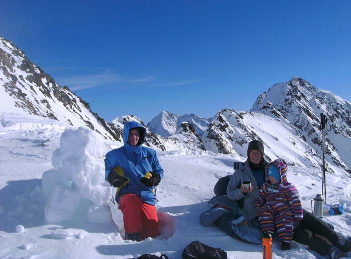 das wilde Mandl ist abgefahren, Ronja aufgewacht, der Rest der Gruppe eingetroffen; Papa hat für Ronja noch schnell eine Schneeburg gebaut ...