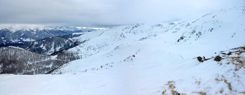 gegenüber das wolkenverhangene Panorama gegen W, vom Ansatz der Karnischen Alpen links bis zum Gipfelhang des Finsterkofel am rechten Bildrand