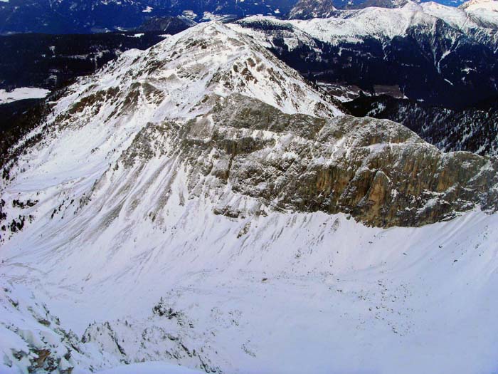 bei Schneearmut von Süden, vom Gipfel der Kinigat, davor die quergestellte Liköfelwand mit einer großen Anzahl von Klettertouren; links die alternative Abfahrt in die Tscharre und das Erschbaumer Tal