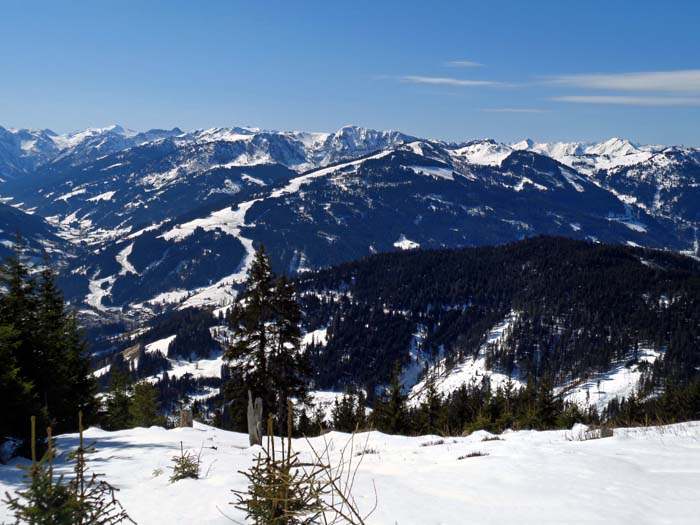 einen umfassenderen Ausblick genießen wir erstmals am flachen Übergang vom Tiefentalkögerl zum Aschegg: hier nach Süden. Die Fortsetzung unserer langen Spur nach Osttirol führt uns von Wagrain (links unten) über die Pistentrassen auf den Kitzstein (Gabel) in Bildmitte und weiter zum Alpenhauptkamm in Richtung Hochalmspitze (links hinten)