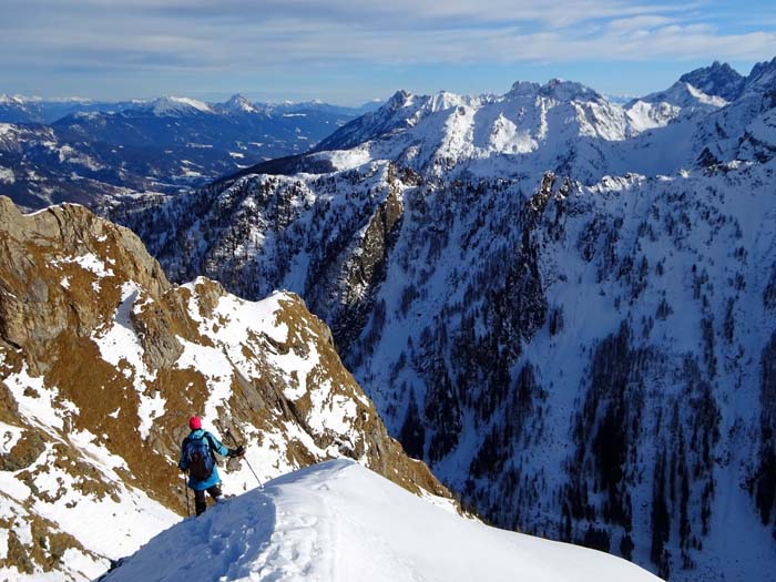 Ulli im Abstieg von der kleinen Schneeschulter auf halber Höhe des NO-Grates, dahinter gestaffelt weitere Karnische Schitourenklassiker, über Gams-, Mittags- und Rauchkofel bis zu den Kellerspitzen ganz rechts hinten