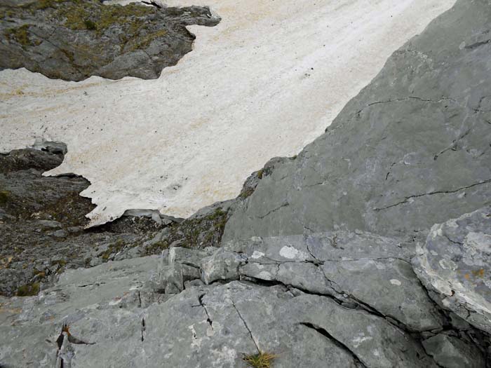 jenseits entweder links über ein steiles Band abklettern oder besser von einem der Zacken 30 m zum Schnee abseilen