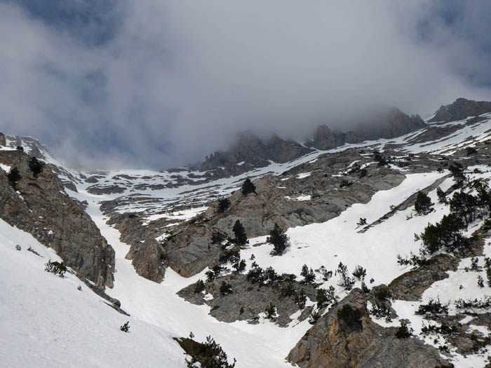 ... und quert über einen latschendurchsetzten Schneehang zurück zur Hauptrinne; das Wetter zieht wieder zu