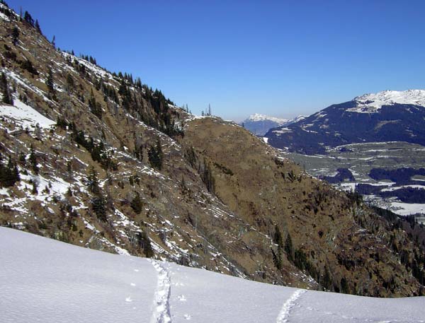 Rückblick von der Achselalm nach N (Pass Thurn); deutlich erkennbar der Jagdsteig, der auf dem Sporn oberhalb der Bildmitte in die neue Forststraße übergeht. Obwohl sich in den steilen Flanken wenig Schnee gehalten hat, können drei harte Rinnenquerungen manchmal Probleme bereiten