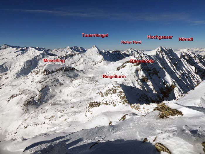 Gipfelpanorama gegen Nordwest; eine Abfahrtsvariante führt knapp unterm Riegelturm rechts hinunter ins schattige Finsterkar auf der Salzburger Seite und zum Tunnel-Nordportal
