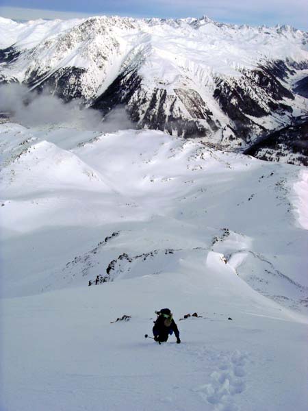 den sehr steilen oberen Gipfelhang der Elferspitze trauen wir uns nur zu Fuß hinunter; der Schnee ist härter als es den Anschein hat, hinter der Schneekante links bricht die felsige Steilflanke ins Gampertal ab; darunter die schöne Abfahrtsmulde zum Zehner hinüber, darüber das Langtauferer Tal und die westl. Ötztaler